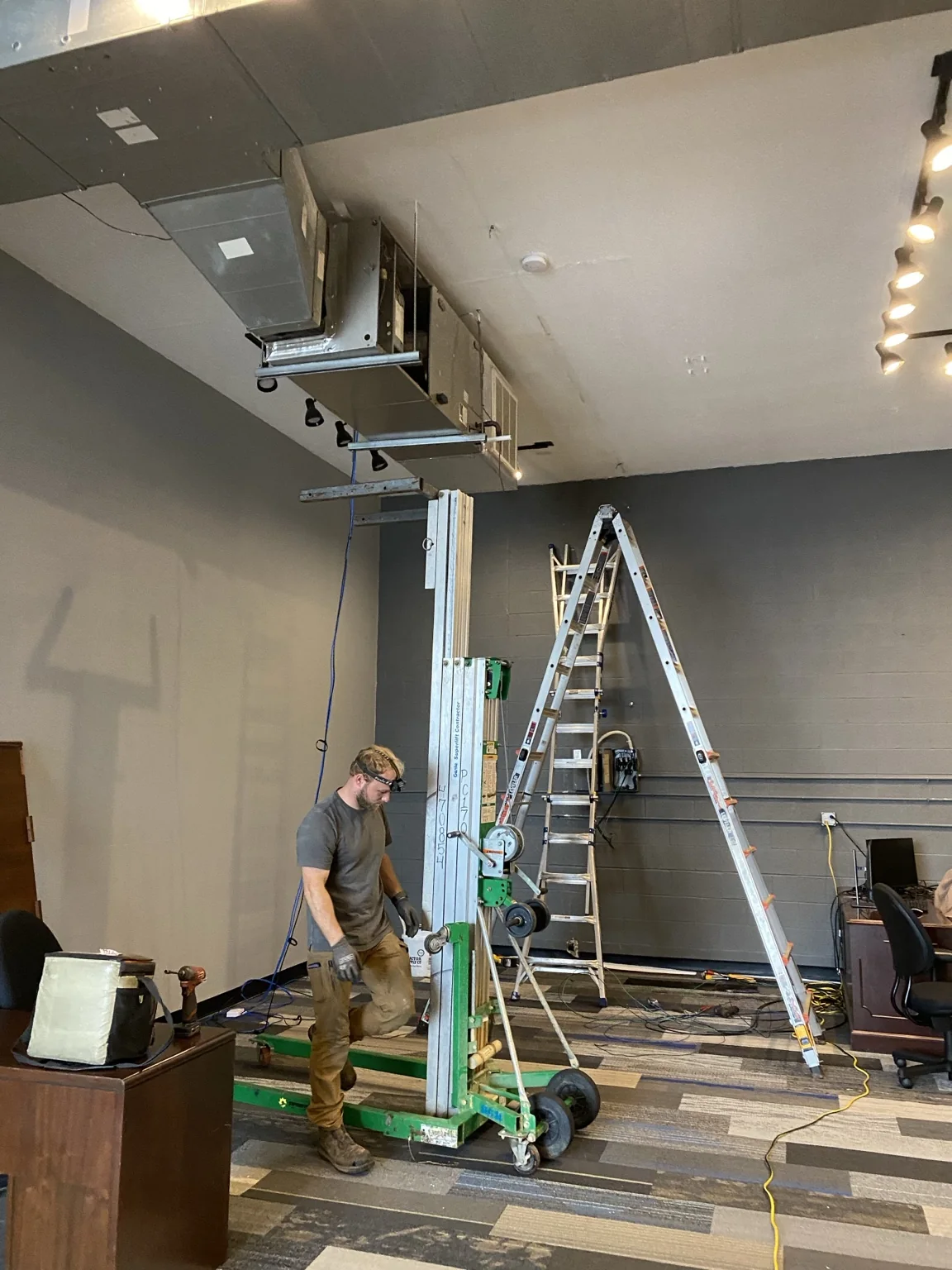 Commercial HVAC technician working beneath suspended ductwork