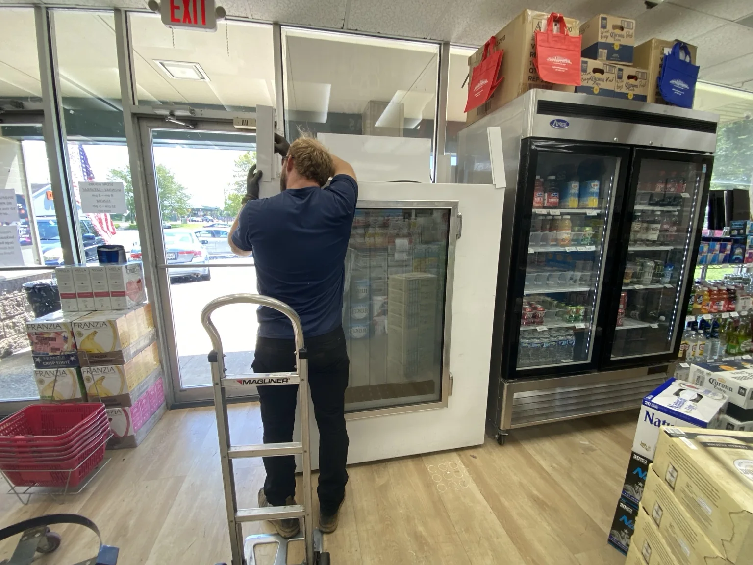 Technician installing commercial refrigerated display equipment